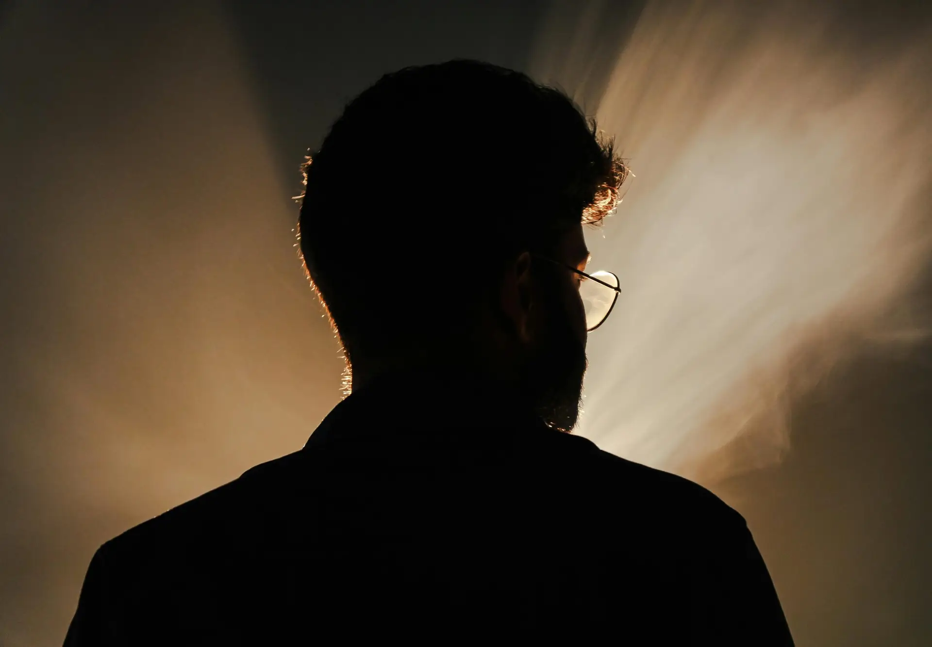 Artistic silhouette portrait with dramatic backlight creating a mysterious and moody atmosphere.